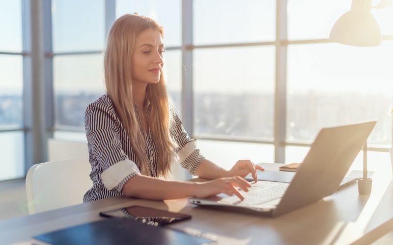 editing-services-young-woman-typing-on-her-laptop-at-the-office-min