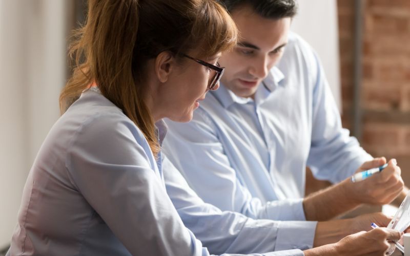 translation-services-businesswoman-and-businessman-discussing-paperwor-min