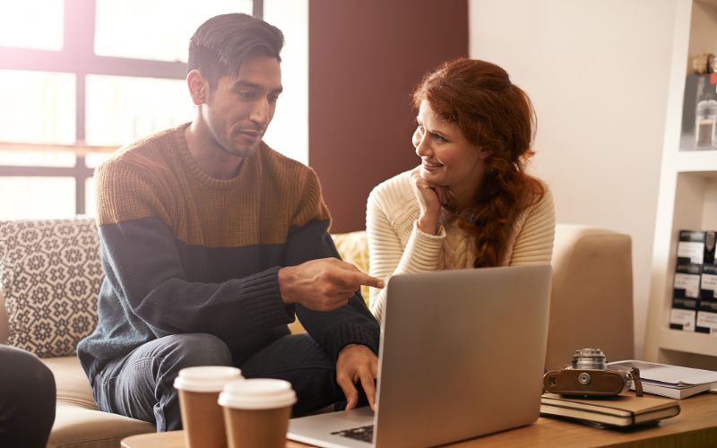 translation-services-young-couple-laptop-and-discussion-in-coffee-shop-min