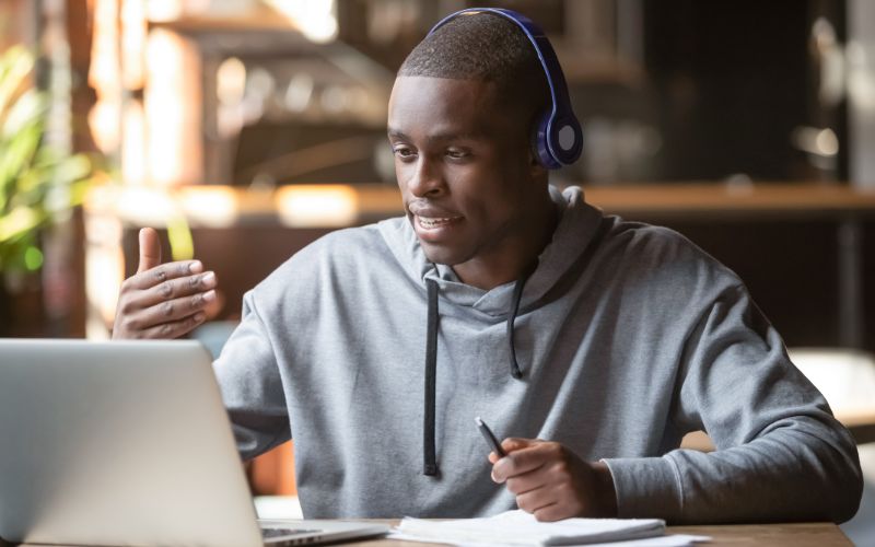 document-translation-services-south-africa-african-american-man-in-headphones-making-video-call-in-cafe-min