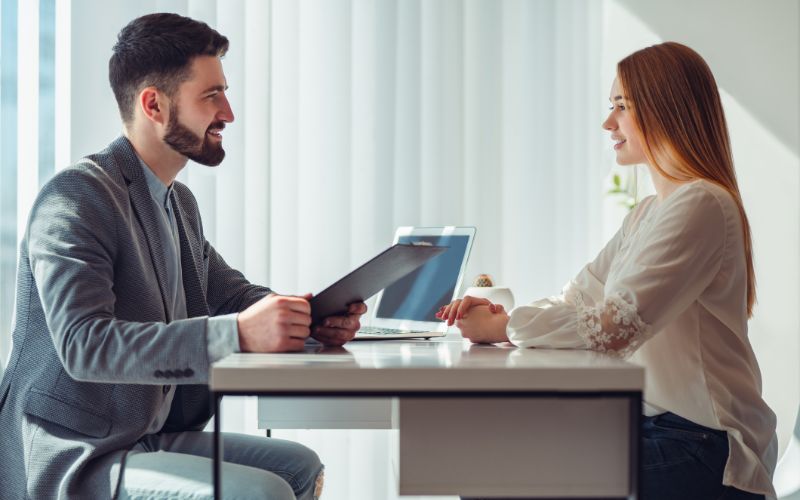 sworn-translator-nervous-woman-looking-at-manager-reading-her-resume-during-a-job-interview-at-office-min
